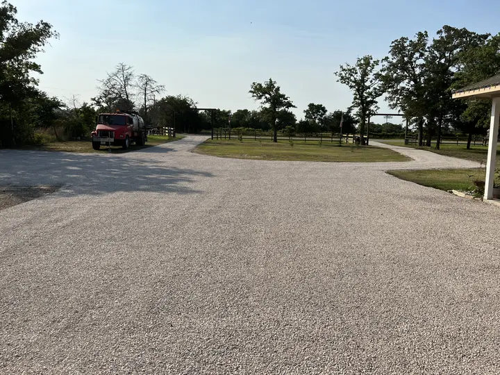 Wide chip seal drive and turnaround under live oaks in Central Texas