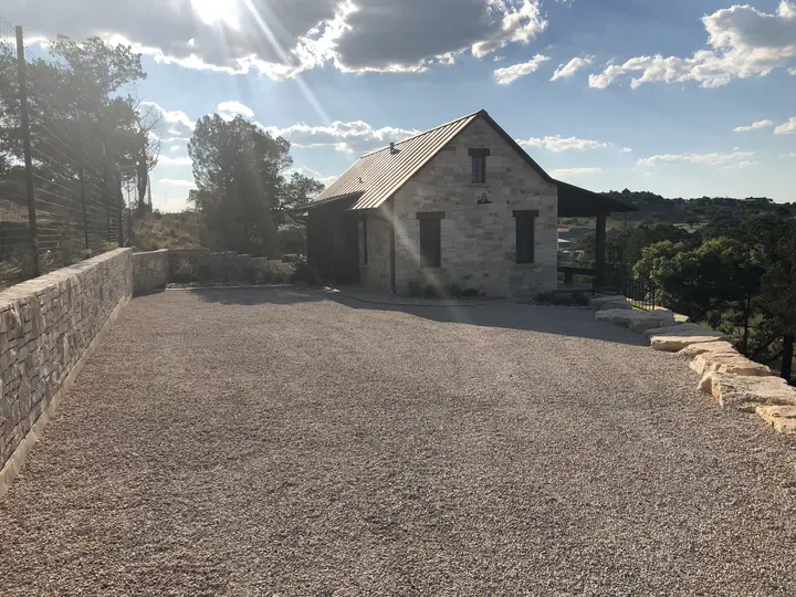 Chip seal court in front of a limestone cottage in the Hill Country